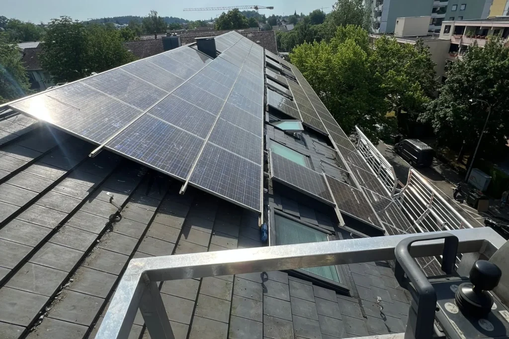 Blick aus dem Arbeitskorb auf ein Ziegeldach mit Montageschienen