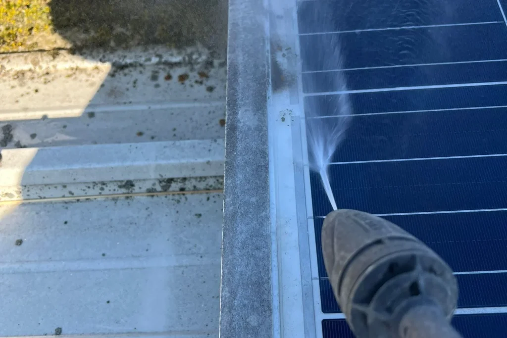 Reinigung eines Solarmoduls mit Hochdrucklanze, Schmutz löst sich am Modulrand