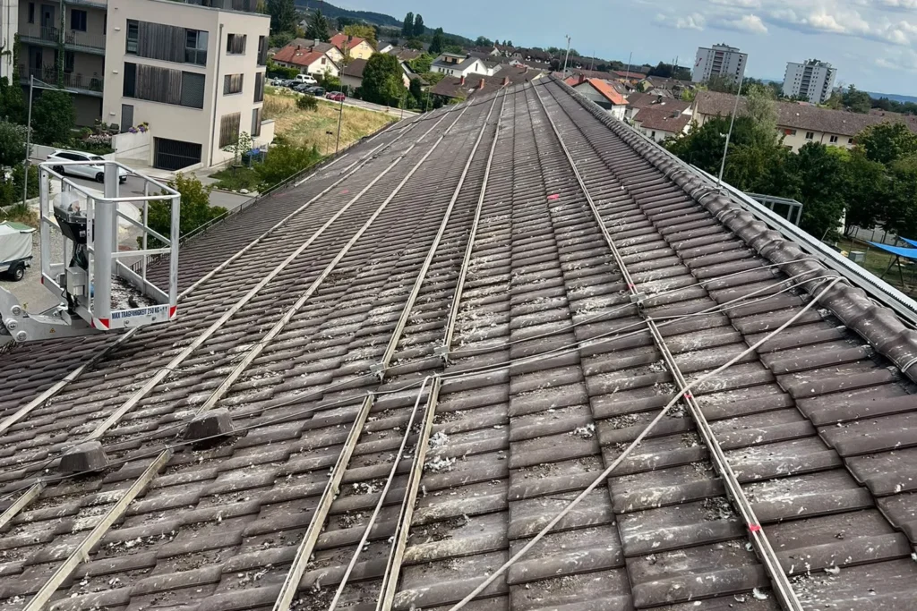 Ziegeldach mit Montageschienen und flächigem Taubenkot zwischen den Reihen